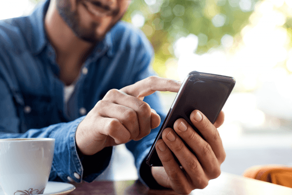 young man using his phone to leverage self-service channels.webp