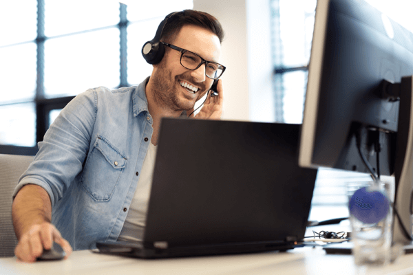 smiling man on headset working to increase call center productivity