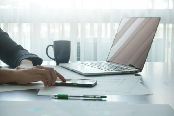 female using mobile smartphone connection while working with laptop in offices, technology and business concepts